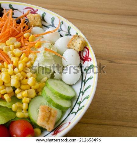 Fresh Green Organic Garden Salad in big bowl on wooden background.