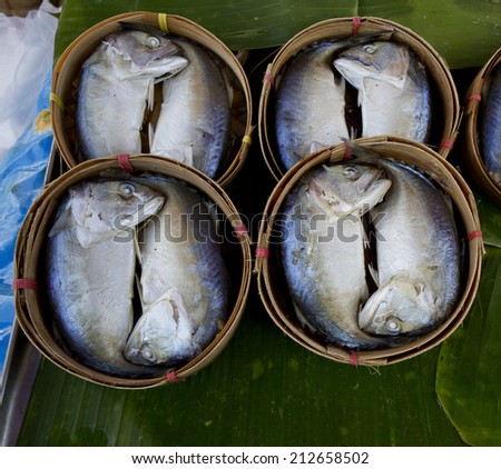 Mackerel fish in bamboo basket on banana leaf.