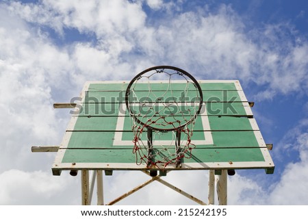 A basketball basket on weathered green wooden facade. Basketball hoop.