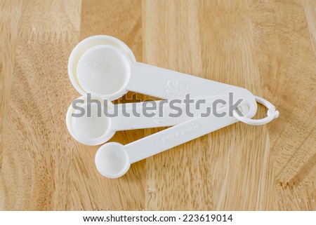 measuring spoons baking utensils ona wood background