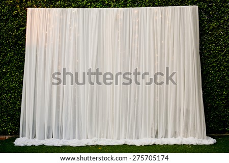 White see through fabric curtain decorate with the lights in wedding ceremony. Wedding Backdrop.
