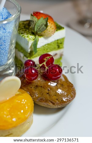 Collection of different delicious desserts and cakes in white plate