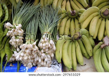 freshly harvested spring onions and bunch banana ready to sell at market