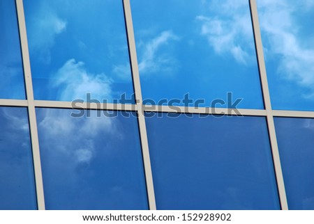 Merida, Yucatan, Mexico, 2008. Glass windows with white frames reflecting blue sky and white clouds.