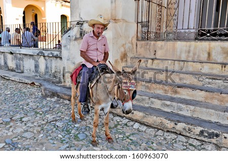 TRINIDAD, CUBA, OCTOBER 27, 2009. An old man sitting on the back of a donkey, in Trinidad, Cuba, on October 27th, 2009.