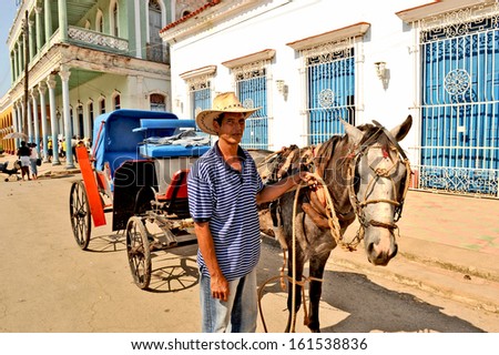 REMEIDOS, CUBA, JULY 7, 2009. A man holding a horse that is attached to a carriage, in Remeidos, Cuba, on July 7th, 2009.