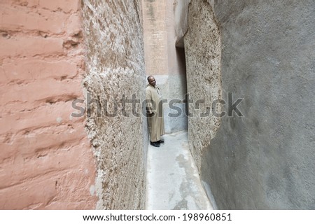 MARRAKECH, MOROCCO, MAY 11, 2014. A tour guide in an alley which leads into the Saadian Tombes Palace,  Marrakech, Morocco, on May 11th, 2014.