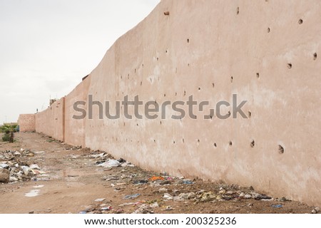 MARRAKECH, MOROCCO, MAY 11, 2014. Part of the barricade wall surrounding the city, with rubbish on the ground, in Marrakech, Morocco, on May 11th, 2014.