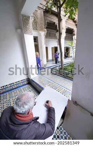 BAHIA PALACE, MARRAKECH, MOROCCO, MAY 11, 2014. An old man painting a picture of the inner coutryard of Bahia Palace, in Marrakech, Morocco, on May 11th, 2014.