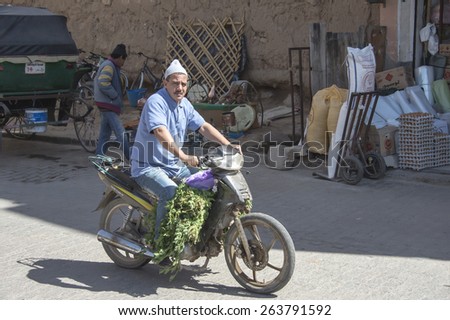 TAROUDANT, MOROCCO, MARCH 5, 2014. A man transporting a load of vegetables with his light motorcycle in the main medina of Taroudant, Morocco, on March 5th, 2014.