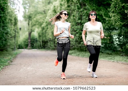 Young and elder woman in sportswear running in the park during the morning exercise