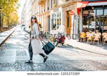 Street view with traditional french cafe and woman walking during the morning in Paris