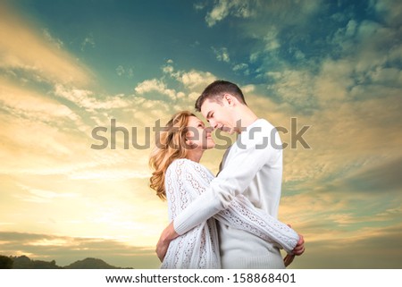 Happy couple embracing and watching one another under the sunny sky