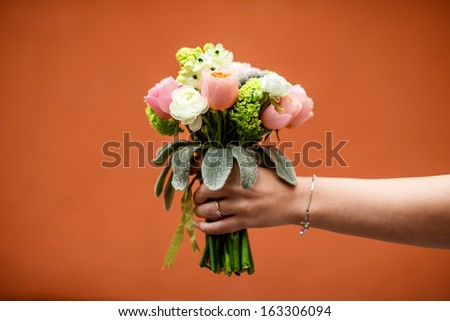 wedding bouquet holding in hands on red background