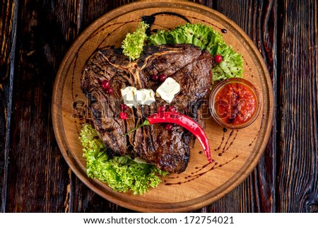 A Big Grilled Steak On A Wooden Plate, Top View