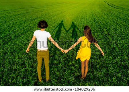 Young couple having fun on the green field in the spring or summer, general plan