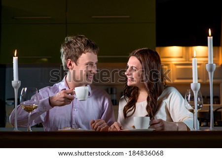Young couple having romantic dinner on the dinner table at home with candle light