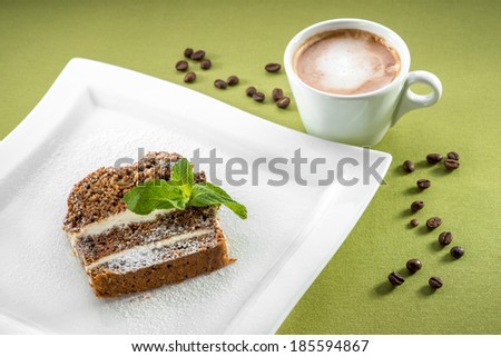 A slice of carrot cake on green background with coffee