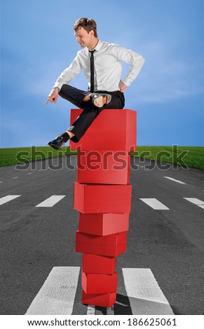 Successful business man on the top of pyramid made of red boxes
