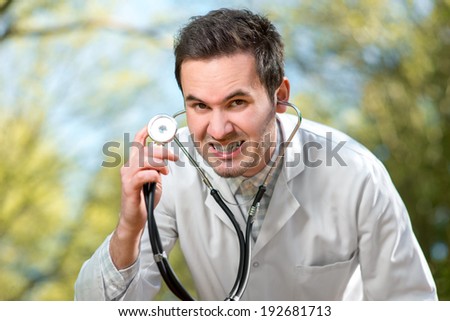 Crazy doctor with stethoscope on green background