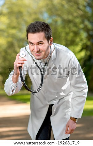 Crazy doctor with stethoscope on green background