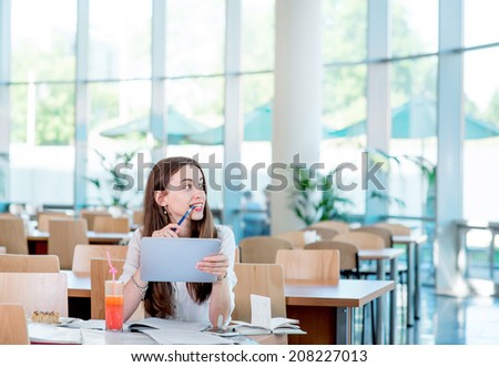 Girl studying in the University canteen with Fresh and cake