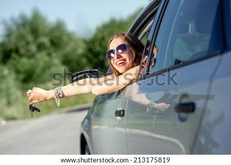 Car driver woman happy showing car keys out window