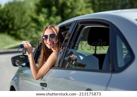 Car driver woman happy showing car keys out window