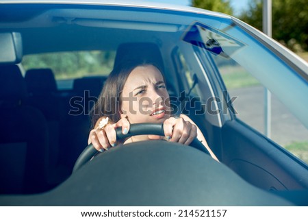 Young woman driving car. Windshield view