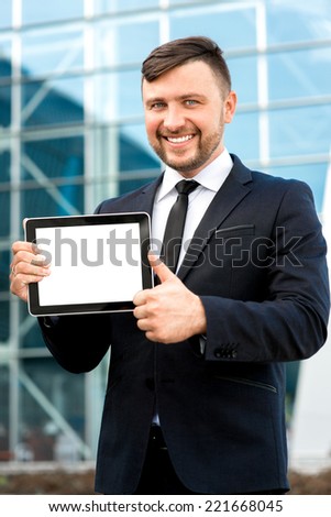 Businessman showing empty screen on the digital tablet on contemporary background