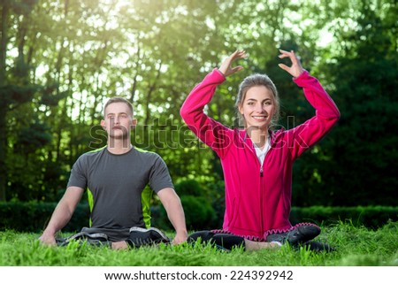 Sports couple in sportwear having yoga in the park