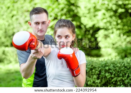 Young sports couple training to box in the park