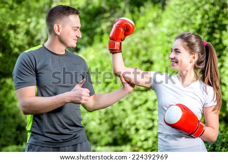Young sports couple training to box in the park