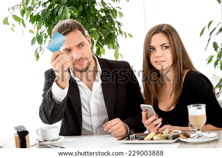 Man with credit card calling the waiter wanting to pay for the order at the restaurant