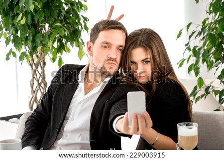 Young couple making selfie photos at the restaurant.