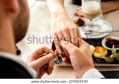 Man making proposal with the ring to his girlfriend at the restaurant.