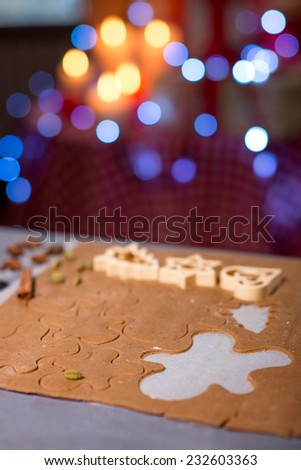 Making ginger cookies on wooden table on festive lighting background