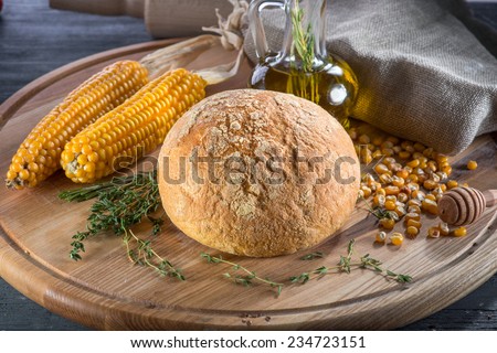 Corn bread with corn olive oil and greens on wooden board