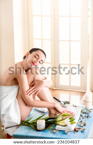 Woman in bath towels having rest sitting in spa salon. General plan with spce for text