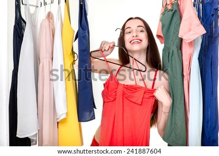 Young happy woman dressed in underwear choosing dress to wear in the wardrobe