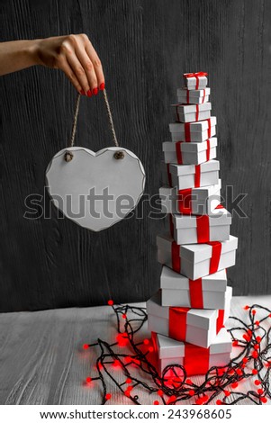 A pile of gift boxes with red ribbons on wooden background with space for text. Greeting card concept