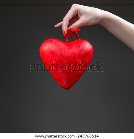 Holding Valentine heart box on the dark background. Greeting card concept