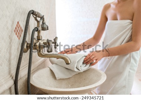Young woman drying hands with towel in the classic style bathroom