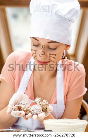 Young woman with painted face holding handmade chocolate candy