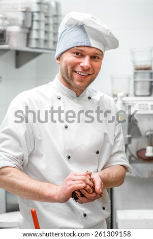 Portrait of handsome confectioner at the restaurant bakery kitchen
