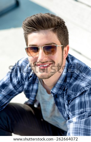 Young handsome man in casual clothes with sunglasses looking at camera