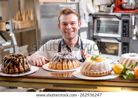 Handsome man in apron with Easter cakes on the kitchen or bakery