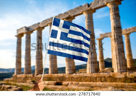 Greek flag on Poseidon temple background in Sounion, Greece