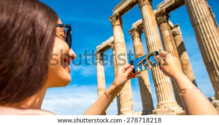 Young woman photographing with smart phone Zeus temple in Greece