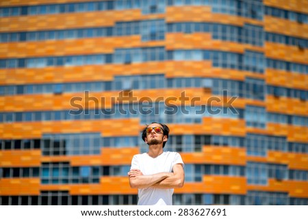 Man standing on the contemporary colorful facade background. General plan with space for your text